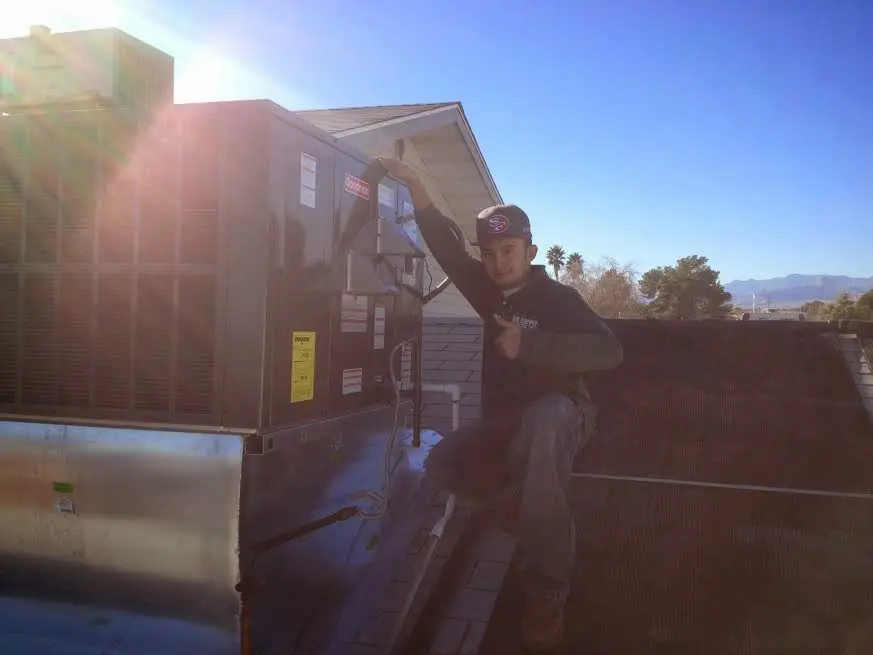 HVAC technician performing Air Duct Cleaning on a rooftop unit in Hendersonville